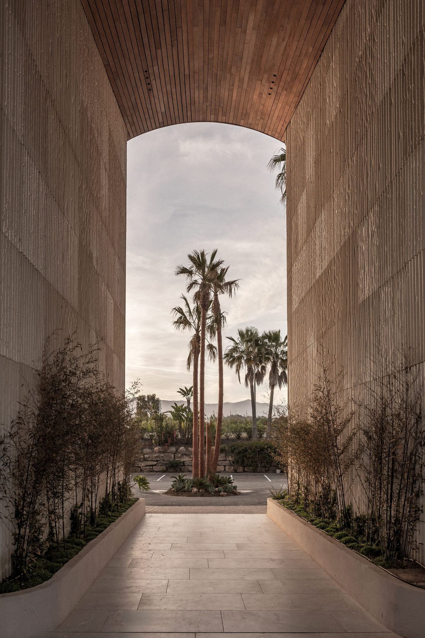 Pasaje con techo de madera abierto a las palmeras — Archidom Laguna, Costa del Sol. Fotografía de Pedro Jaén