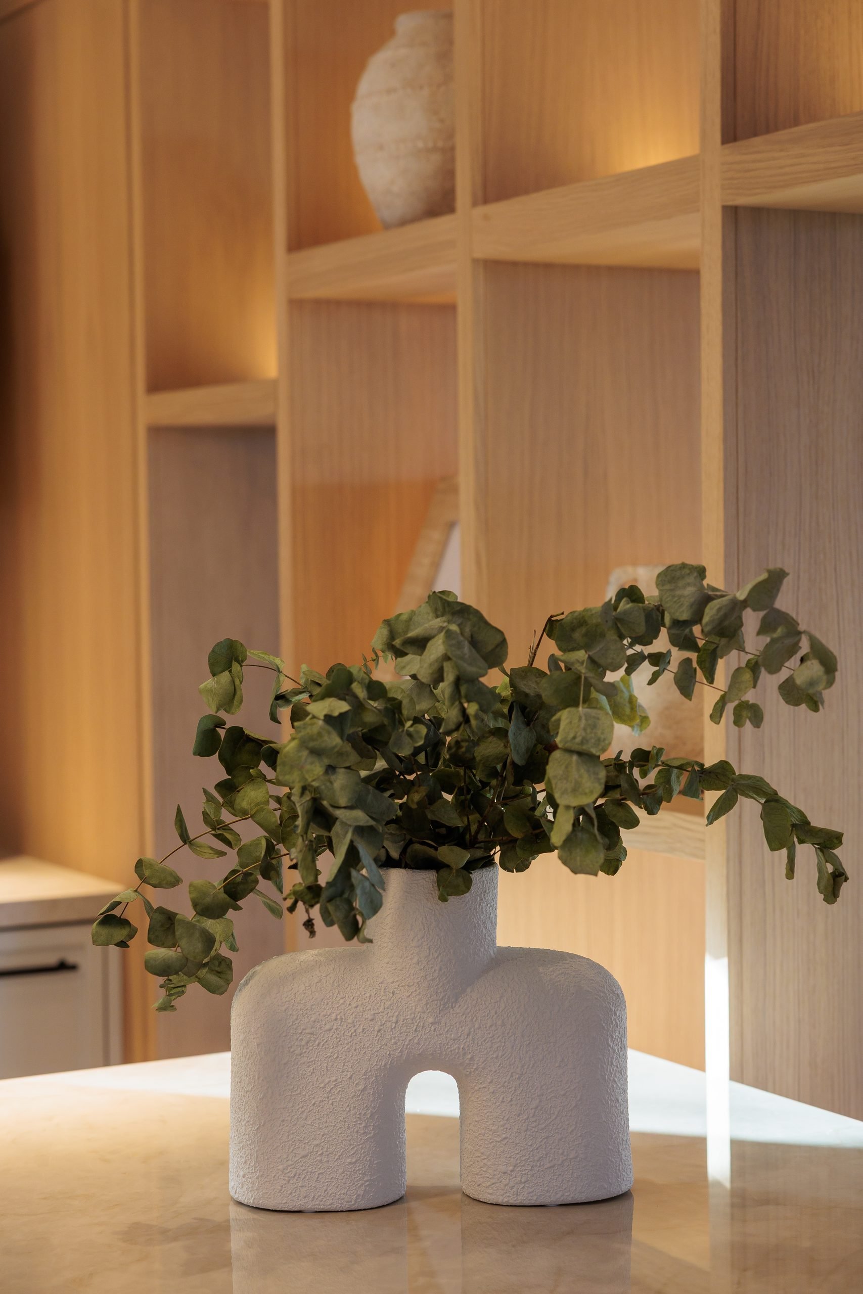 Jarrón blanco con ramas sobre estantería iluminada — CG Studio, Costa del Sol. Fotografía de Pedro Jaén