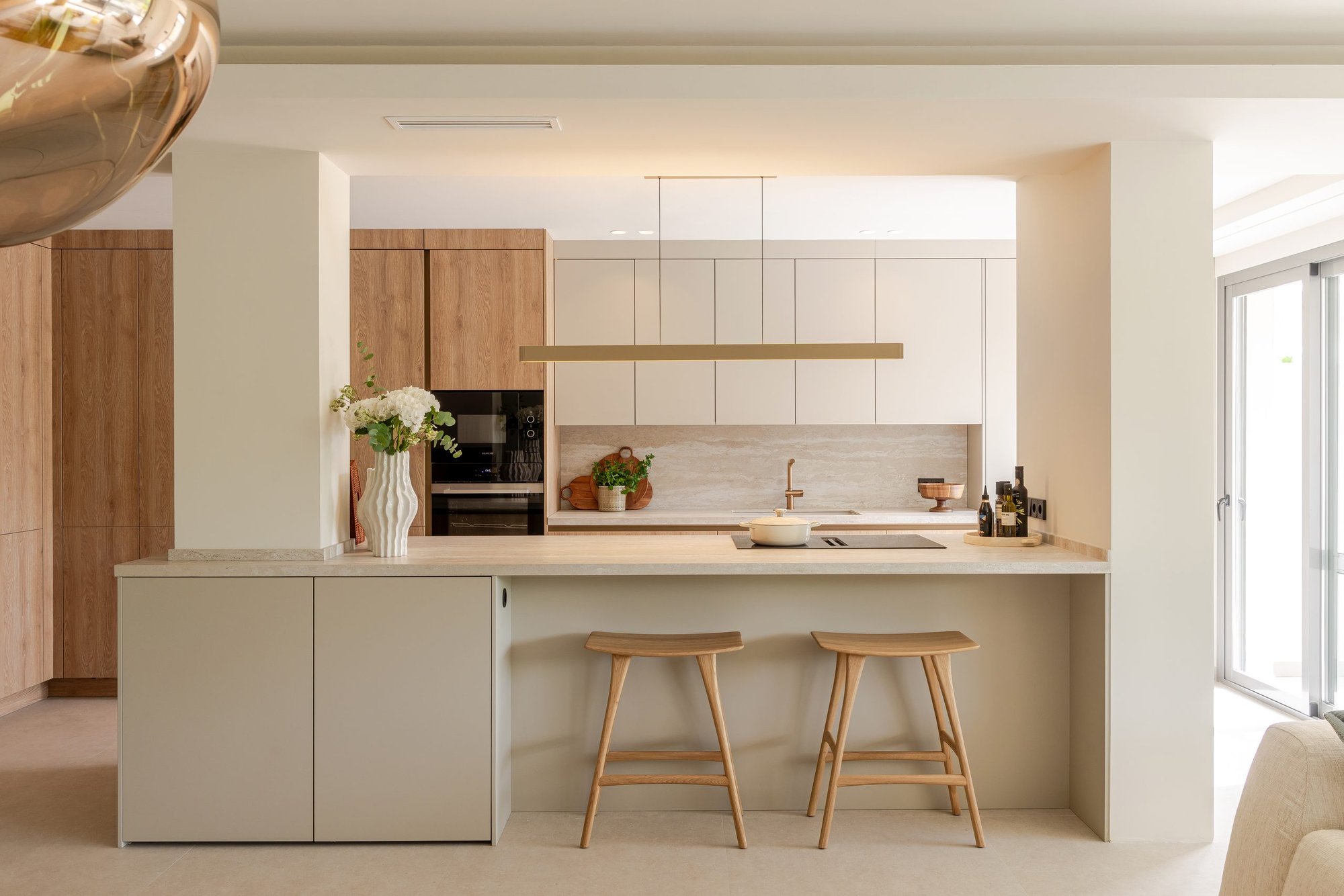 Cocina abierta con isla y taburetes de madera — Concept Living Caroline, Costa del Sol. Fotografía de Pedro Jaén
