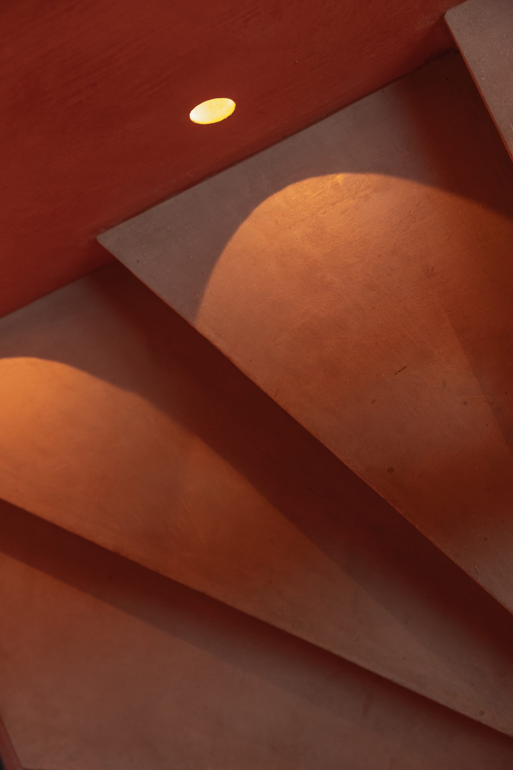 Escalera de microcemento terracota con luz cenital — Endless Istán, Istán, Málaga. Fotografía de Pedro Jaén