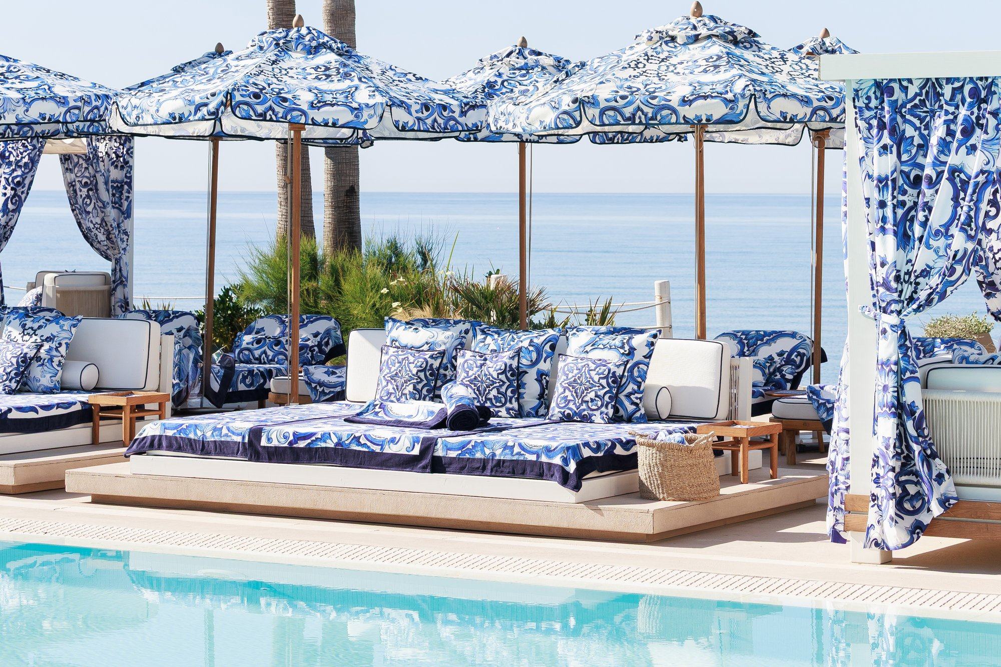 Zona de piscina con camas balinesas y sombrillas majólica — La Cabane · Marbella. Fotografía de Pedro Jaén