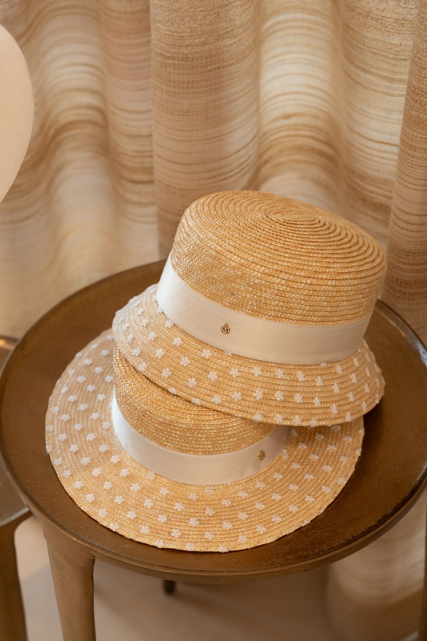 Detalle de sombreros de paja sobre mesa de madera — Maison Michel + Goossens, Marbella Club Hotel, Marbella. Fotografía de Pedro Jaén