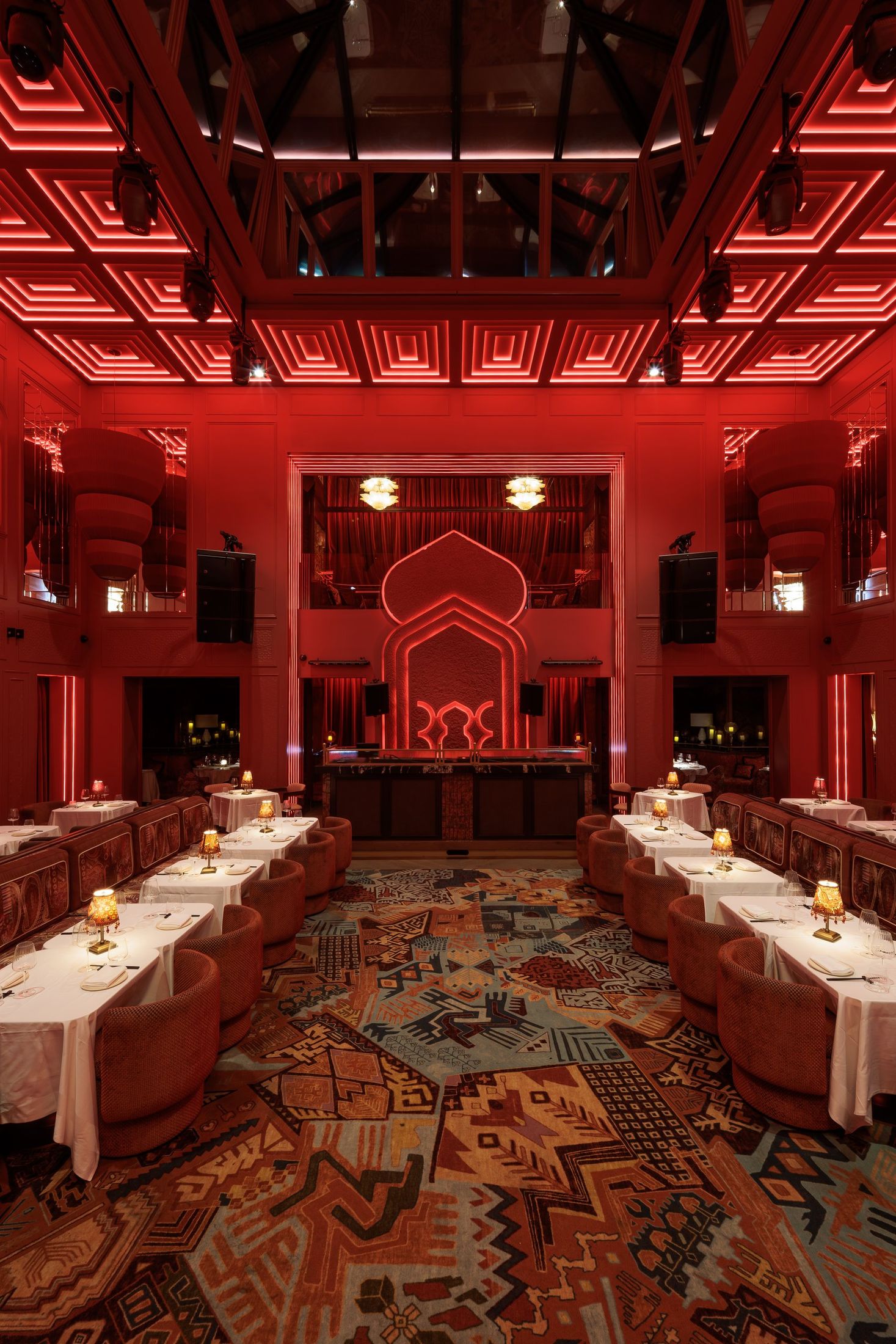Salón de doble altura con techo artesonado de neón y lucernario — Motel · Nuevo, Marbella. Fotografía de Pedro Jaén