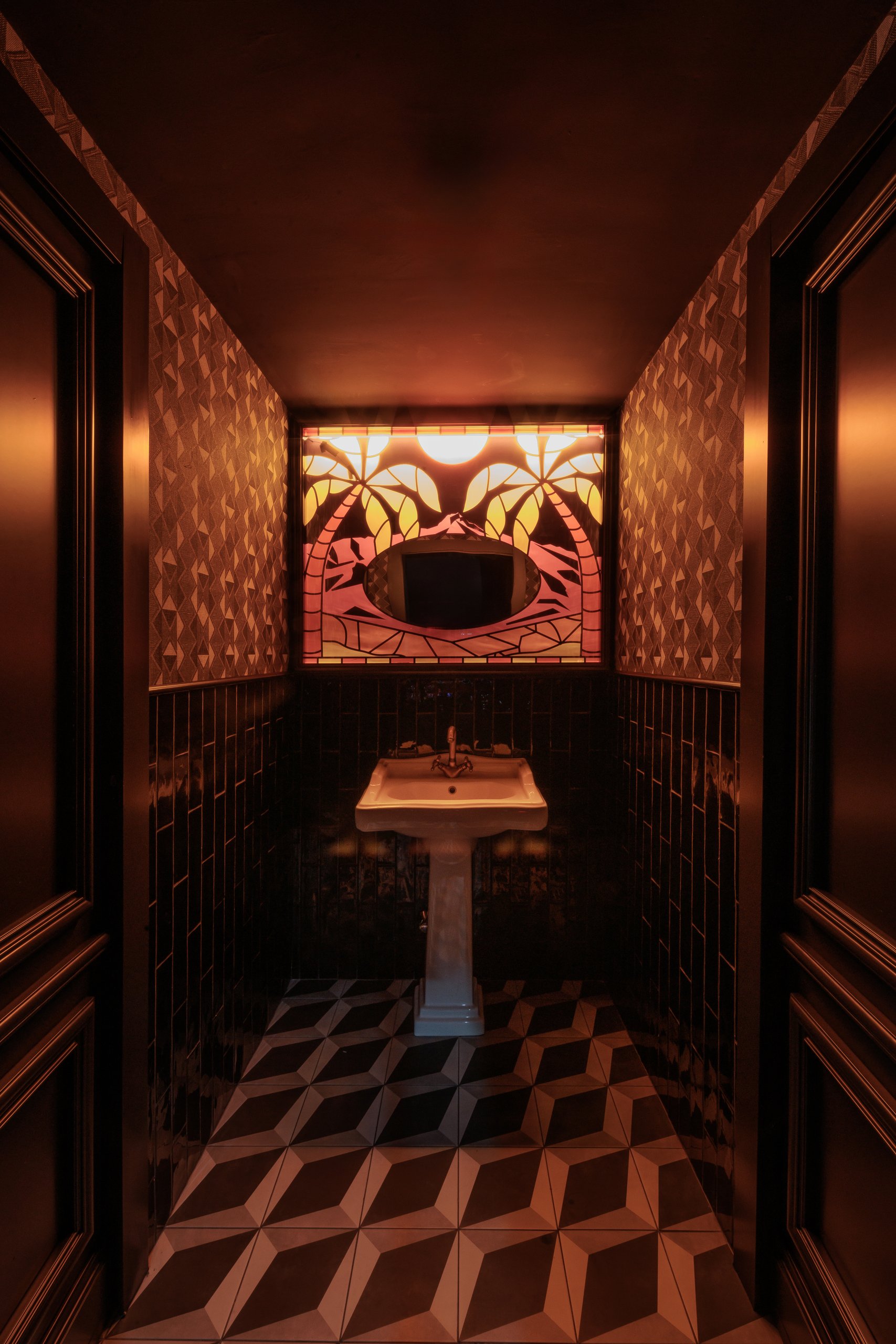 Lavabo con mural de palmeras y suelo de cubos — Motel, Marbella. Fotografía de Pedro Jaén