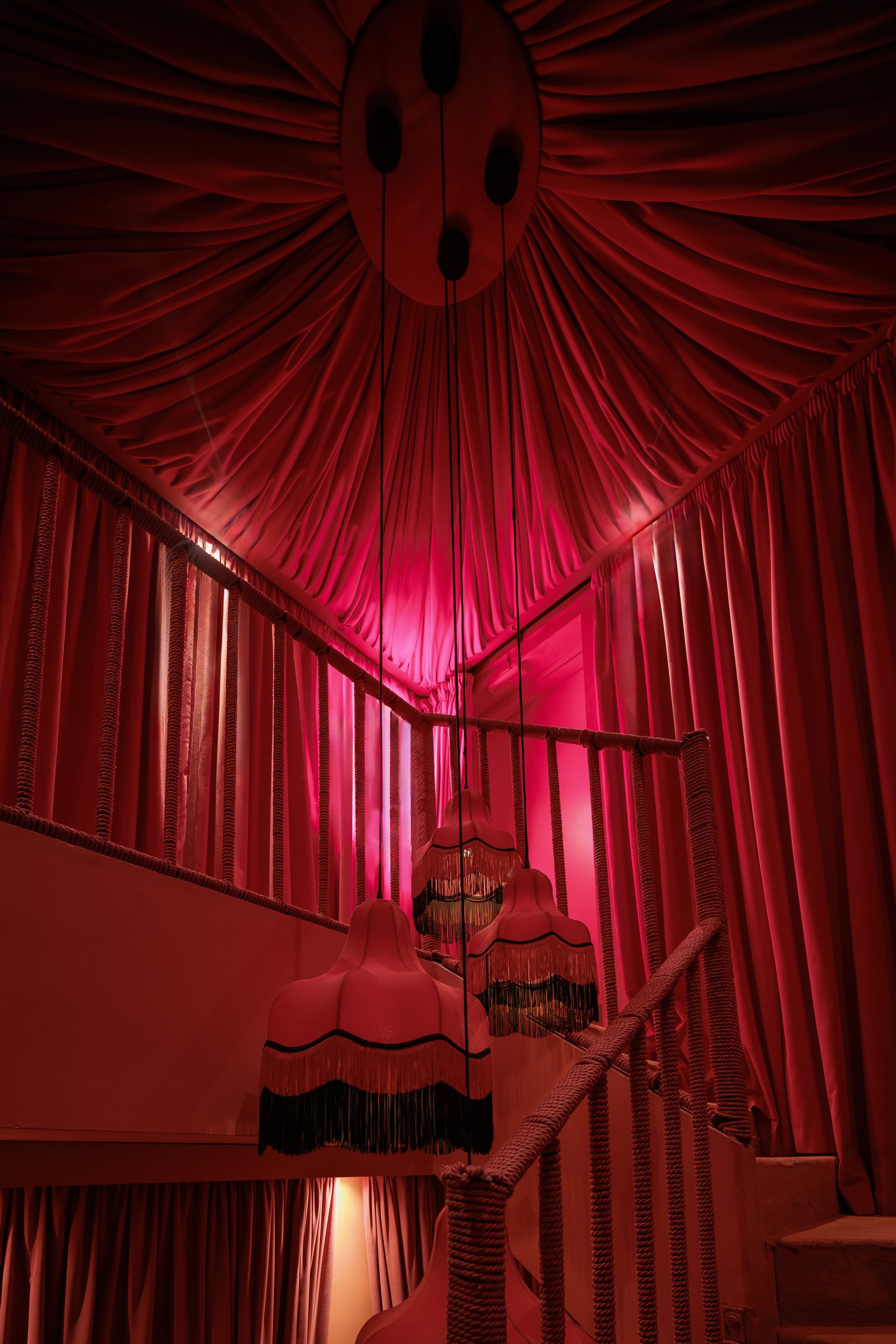 Escalera entre cortinas y lámparas de flecos — Motel, Marbella. Fotografía de Pedro Jaén