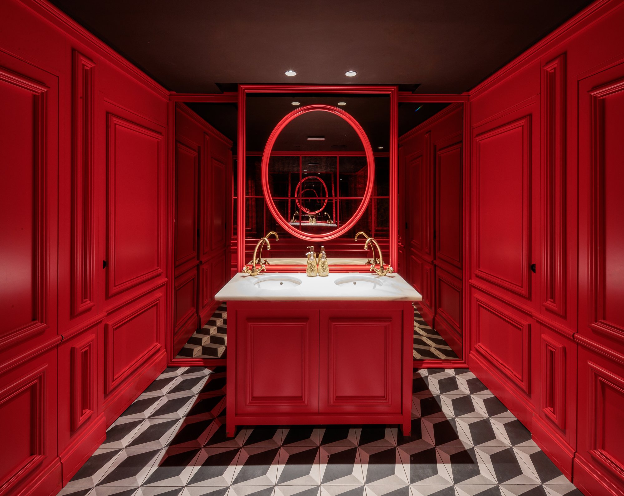 Aseo rojo con lavabo doble y espejo ovalado — Motel, Marbella. Fotografía de Pedro Jaén