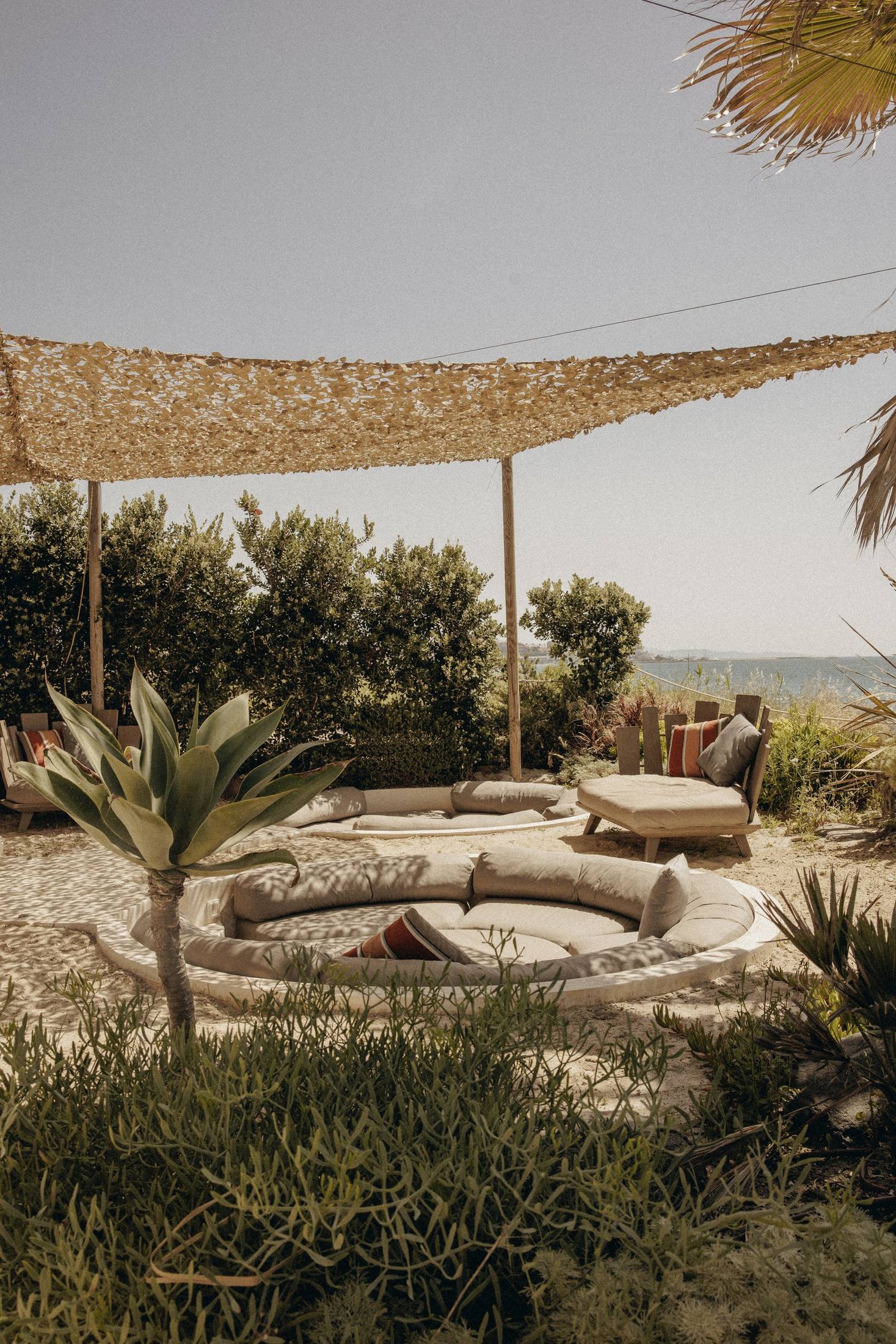 Salón hundido en la arena bajo la red de sombra — Nido, Marbella. Fotografía de Pedro Jaén