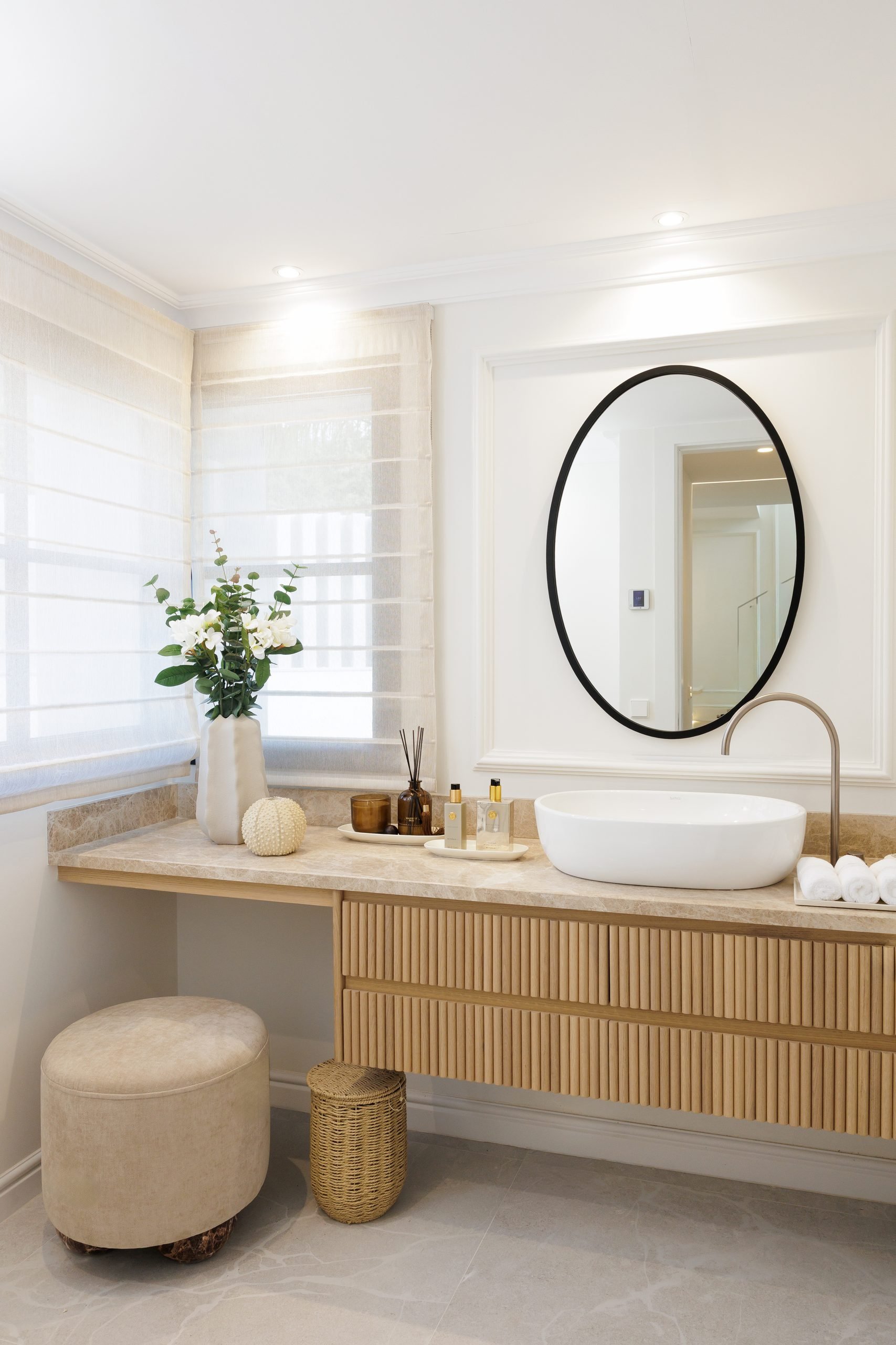 Tocador de madera con lavabo sobre encimera y espejo redondo — Soledad Merchán Villa. Fotografía de Pedro Jaén