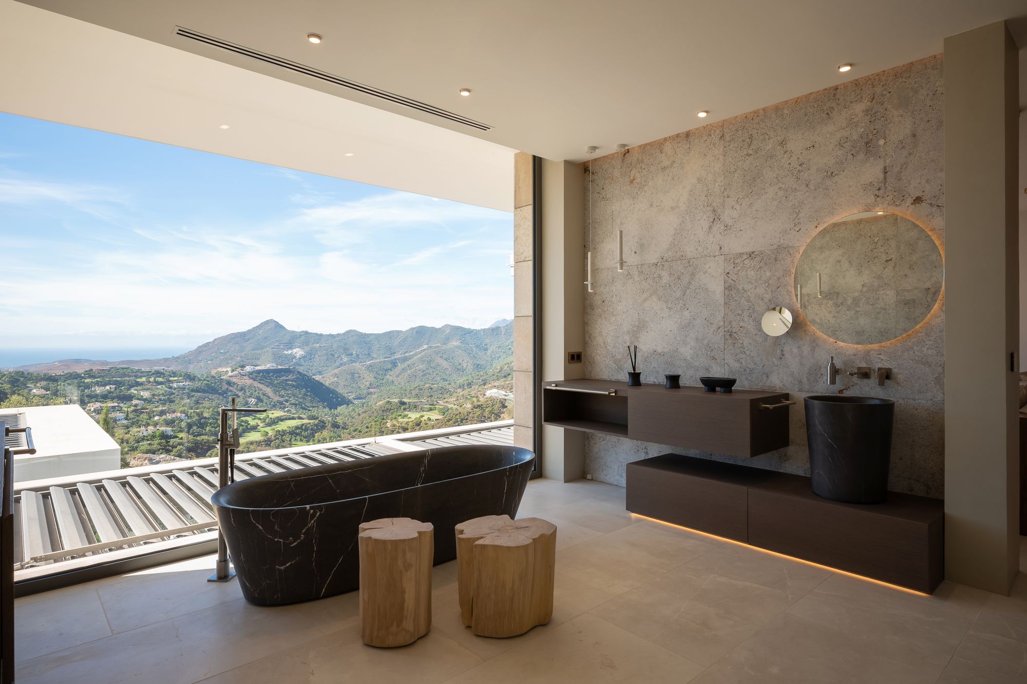 Baño con bañera de mármol frente al paisaje — Villa Kaizen · La Zagaleta. Fotografía de Pedro Jaén
