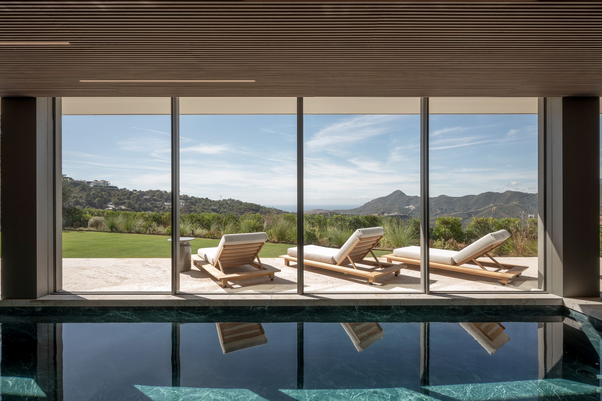 Piscina interior abierta al jardín y a la sierra — Villa Kaizen · La Zagaleta. Fotografía de Pedro Jaén