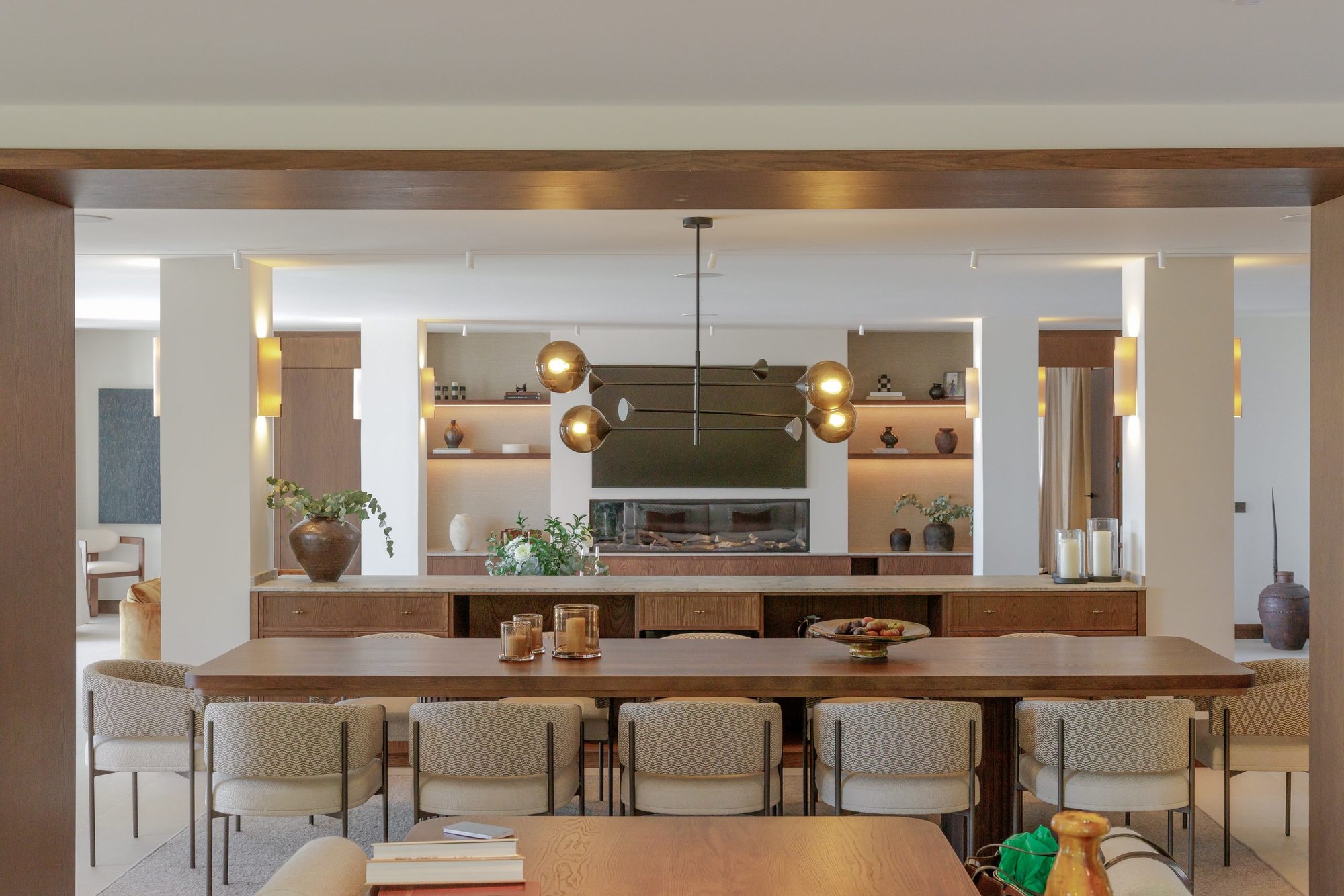 Comedor y cocina abierta con madera y luz cálida — Villa Kronenburg, Nagüeles, Marbella. Fotografía de Pedro Jaén
