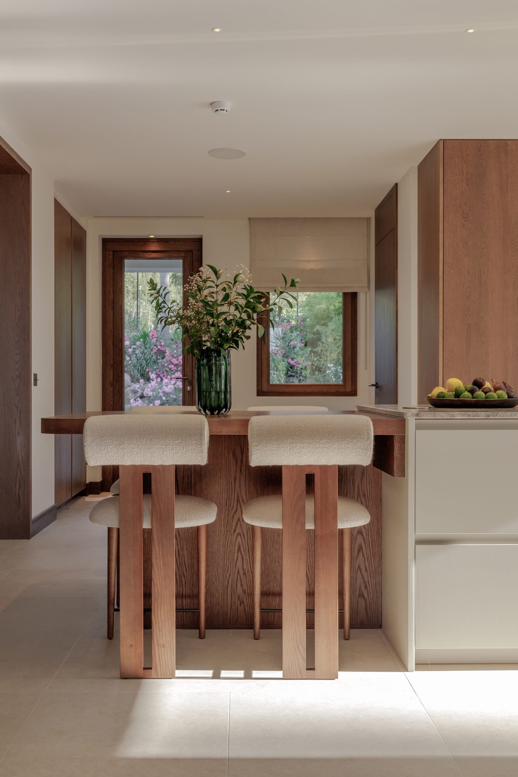 Cocina con isla de madera y taburetes — Villa Kronenburg, Nagüeles, Marbella. Fotografía de Pedro Jaén