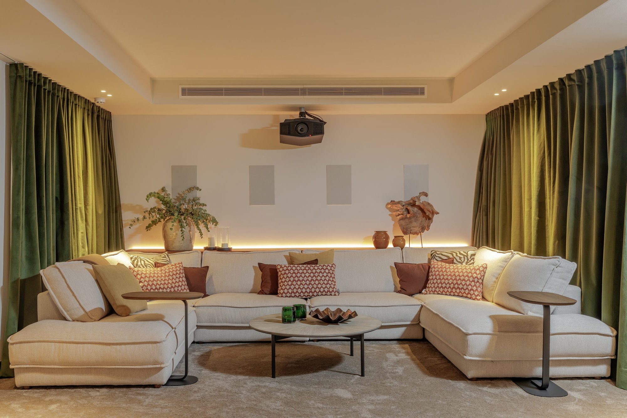 Sala de cine con sofá y cortinas verdes — Villa Kronenburg, Nagüeles, Marbella. Fotografía de Pedro Jaén