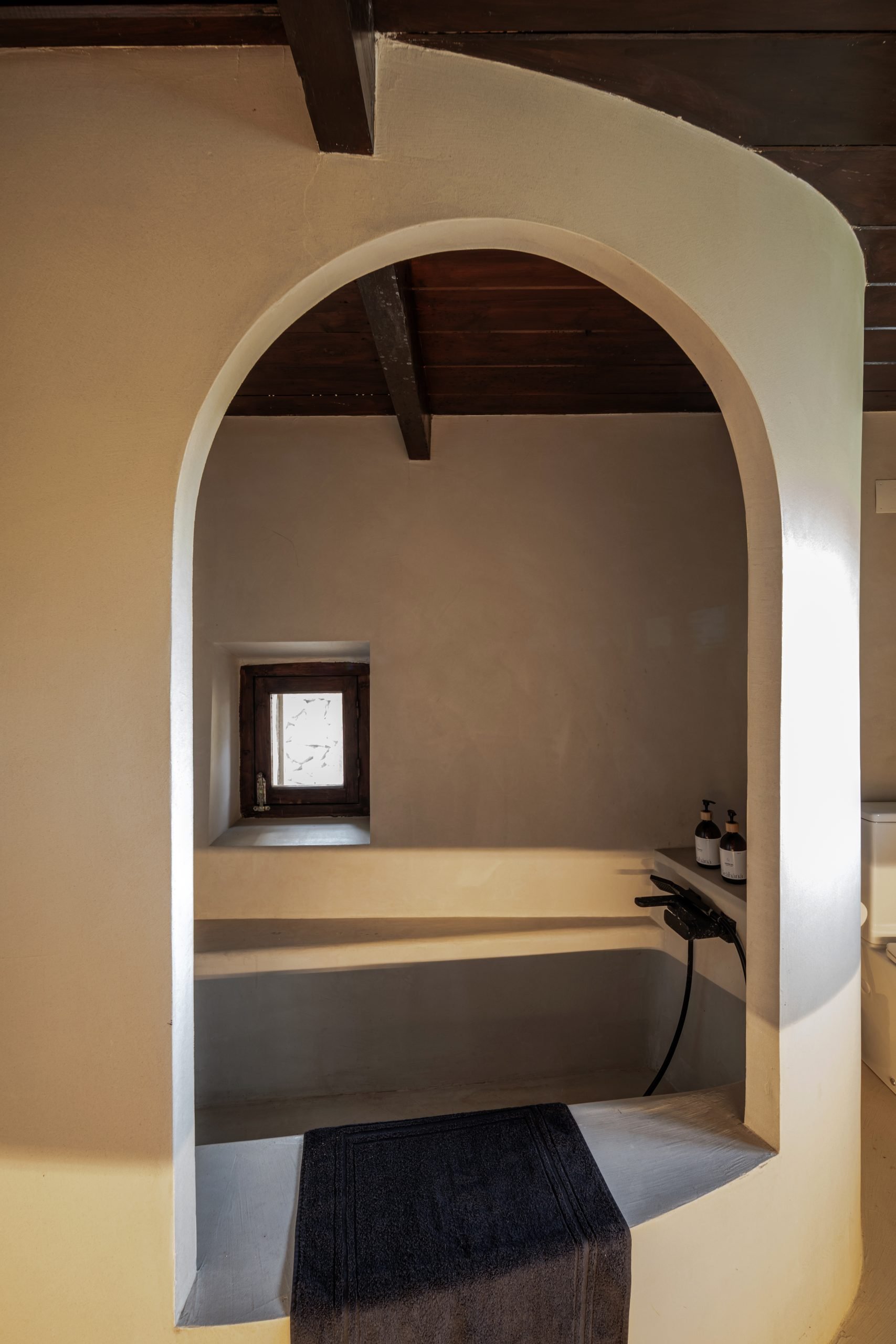 Baño bajo arco encalado con ventana pequeña — Villa The Cave, Tarifa, Cádiz. Fotografía de Pedro Jaén