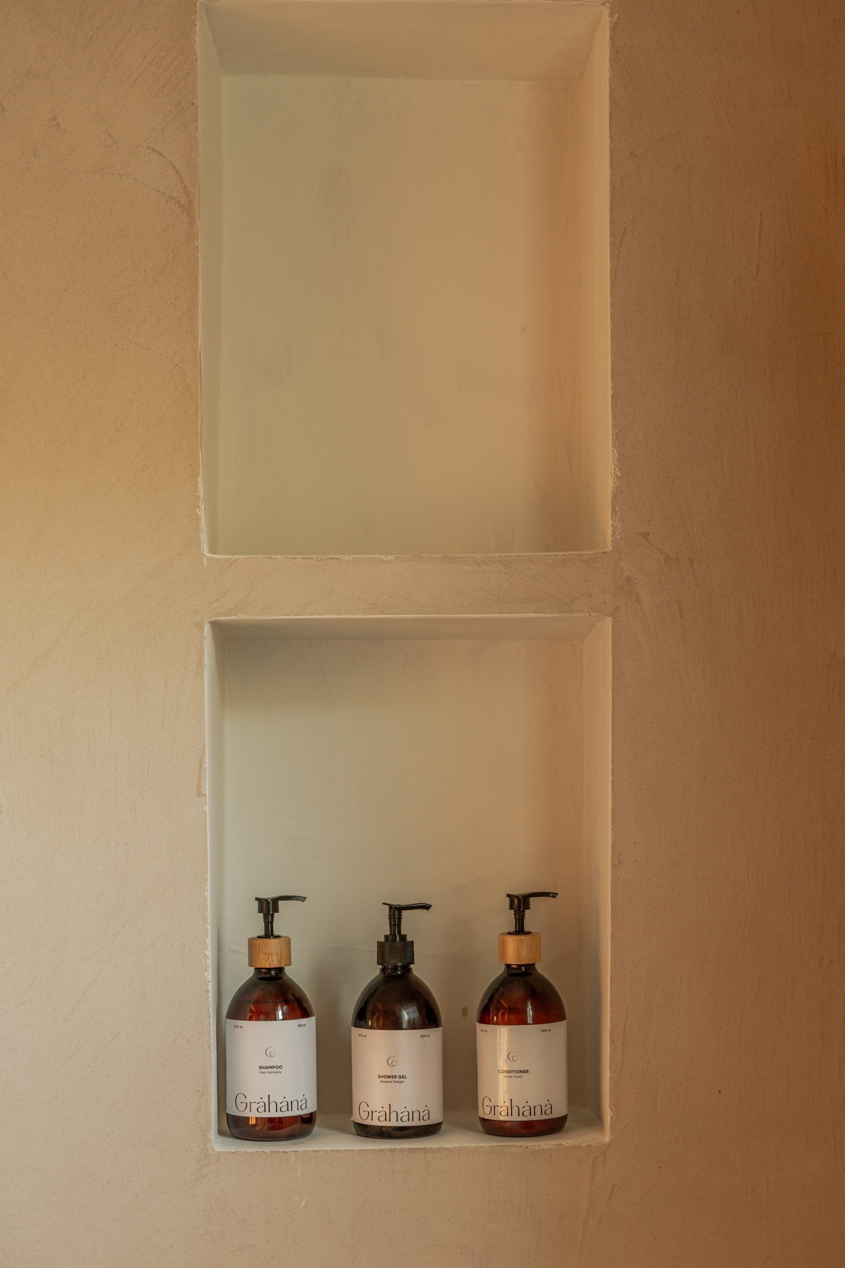 Hornacinas de microcemento con frascos de baño de cristal ámbar — Villa The Cave, Tarifa, Cádiz. Fotografía de Pedro Jaén